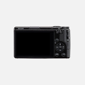 Retro della Ricoh GR IV con lo schermo touch da 3 pollici, il logo RICOH, la leva ADJ e la pulsantiera che si raggiunge con il solo pollice