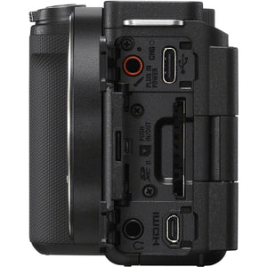 Fianco sinistro della Sony ZV-E10 II con gli sportelli aperti: presa microfono, porta USB-C con la spia di ricarica, slot per la scheda SD, micro HDMI e presa cuffie