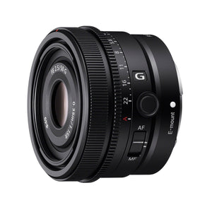 Obiettivo Sony FE 50mm F2.5 G di tre quarti dal davanti, con la lente frontale trattata, la sigla FE 2.5/50 G e la distanza minima di messa a fuoco 0.35m stampate attorno al filtro da 49 mm, la ghiera dei diaframmi da 2.5 a 22 con la posizione automatica A in rosso, il logo G, il pulsante di blocco della messa a fuoco e il selettore AF/MF