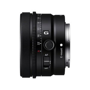 Sony FE 50mm F2.5 G di profilo dal lato dei comandi, che mostra quanto è corto: la ghiera di messa a fuoco zigrinata, la ghiera dei diaframmi con la scala fino a 22 e la posizione A in rosso, il logo G, il pulsante di blocco della messa a fuoco, il selettore AF/MF e la scritta E-mount accanto all'innesto