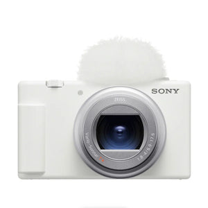 Fotocamera Sony ZV-1 II bianca vista di fronte, con obiettivo ZEISS Vario-Sonnar T* e paravento antivento montato