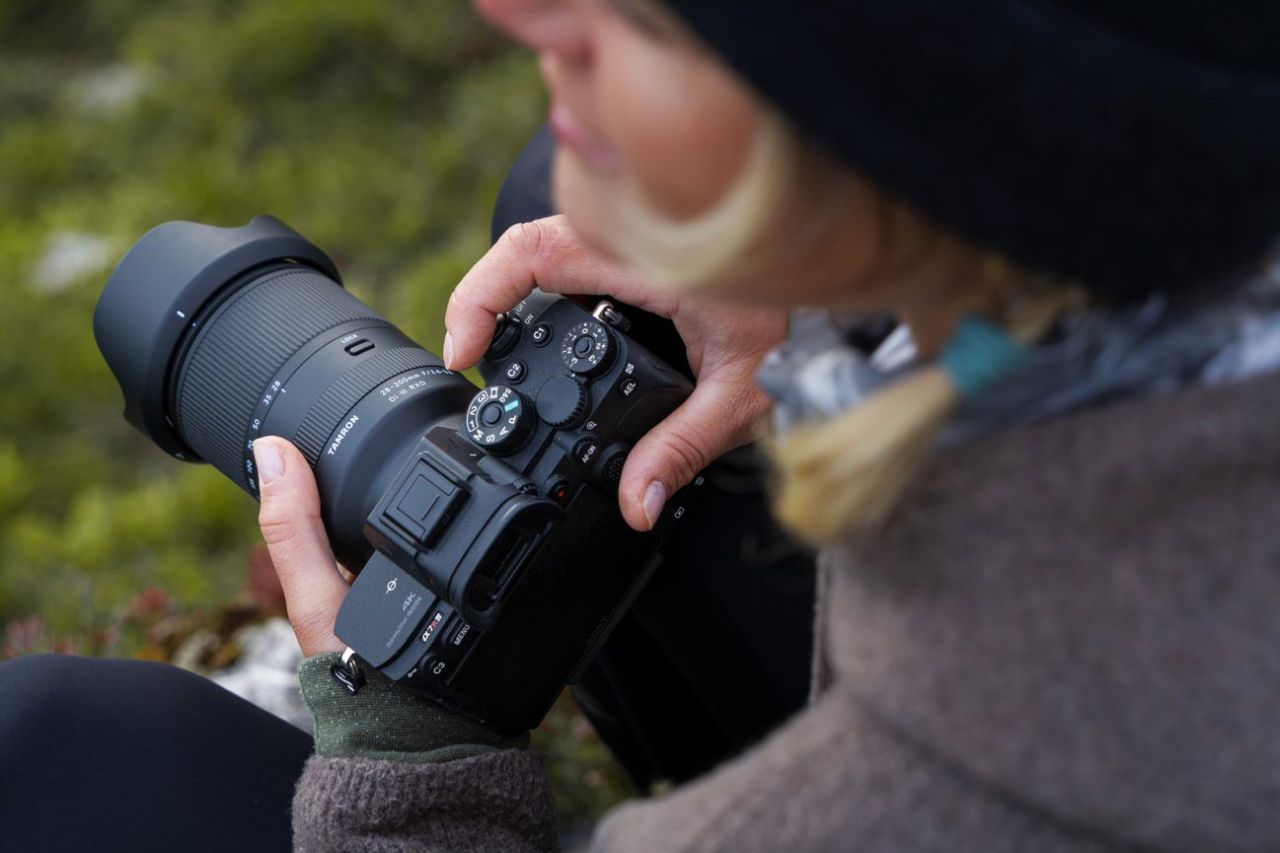 Tamron 28-200mm montato su fotocamera Sony impugnata da una fotografa all'aperto