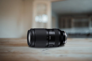 Tamron 70-180mm f/2.8 Di III VC VXD G2 appoggiato su un piano di legno